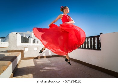 Attractive Flamenco Dancer Wearing Traditional Red Dress With Flower In Her Hair