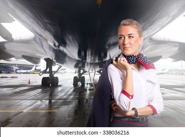 Attractive Flight Attendant Near Airplane In Airport.