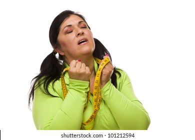Attractive Frustrated Hispanic Woman With Tape Measure Against A White Background.