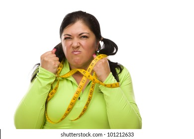 Attractive Frustrated Hispanic Woman Tied Up With Tape Measure Against A White Background.