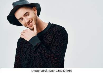 Attractive Gentleman In A Sweater And Black Hat Holds His Hand Near The Face                             