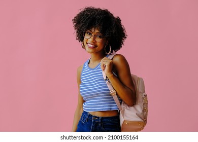 attractive girl in eyeglasses with backpack posing on pink background, back to school concept - Shutterstock ID 2100155164