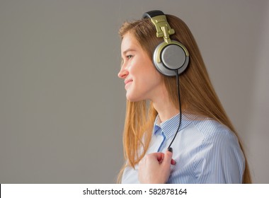 attractive girl with headphones on gray background. - Shutterstock ID 582878164