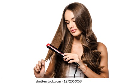 Attractive Girl Holding Hair And Using Straightener Isolated On White