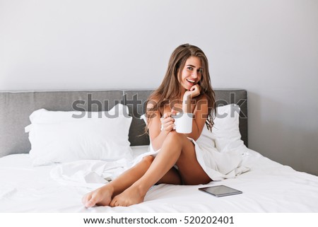 Attractive Girl With Naughty Shoulders And Legs Drinking Coffee On Bed In The Morning In Modern Attractive Girl With Naughty Shoulders And Legs Drinking Coffee On Bed In The Morning In Modern