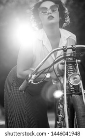 Attractive girl on an old motorcycle in the Park . Girl in retro clothes with retro motorcycle