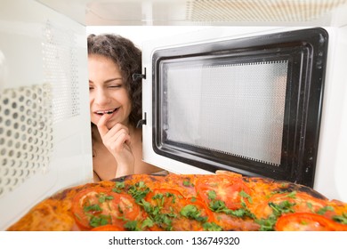 Attractive girl open  a microwave