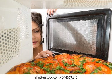Attractive girl open  a microwave