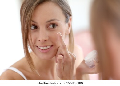 Attractive Girl Putting Anti-aging Cream On Her Face