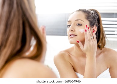 Attractive Girl Putting Anti-aging Cream On Her Face