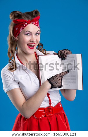 An attractive girl with a red bandana on her head laughingly points to the text of the book. Girl in pin- up style isolated on blue background