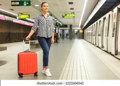 Attractive girl with red suitcase walking on underground station - Shutterstock ID 1222604542