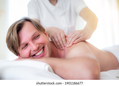 attractive handsome Caucasian man having body massage by Thai Masseur in spa salon. Beauty treatment and body care lifestyle concept