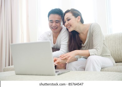 Attractive Happy Asian Couple Using Laptop