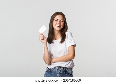 Attractive Happy Brunette Girl Laughing And Holding Credit Card, White Background