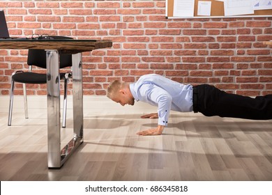 Attractive Happy Businessman Doing Push Up In Modern Office - Powered by Shutterstock
