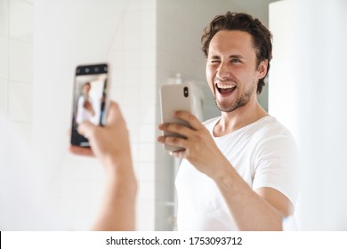 Attractive Happy Confident Young Man Standing In Front Of The Bathroom Mirror, Taking A Selfie