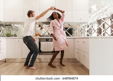 Attractive Happy Couple Dancing In The Kitchen. Black Woman And White Man.