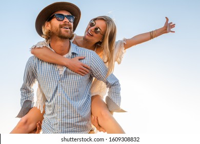 Attractive Happy Couple Laughing Traveling In Summer By Sea, Man And Woman Wearing Sunglasses, Boho Hipster Style Fashion Having Fun Together