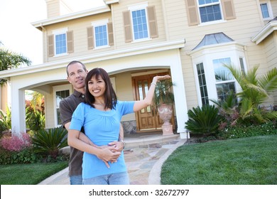 An Attractive Happy Diverse Couple In Front Of Their Home In Love