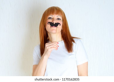 Attractive Happy Middle Aged Woman Having Fun With A Fake Moustache On Stick. Senior  Female In The Period Menopause. Lifestyle, Women's Health Concept : Playful Blond Red Hair Mature Ready For Party.