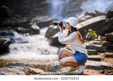 attractive happy smile asian woman photographer holding professional camera in green moisture forest - Powered by Shutterstock