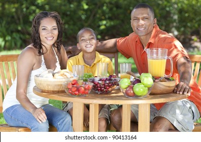 An Attractive Happy, Smiling African American Family Of Mother, Father, Son, Man Woman, Boy Child Eating Healthy Food At A Picnic Table Outside