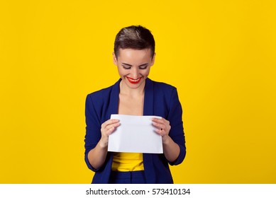 Attractive Happy Young Business Woman Smiling Opening Looking Inside A White Envelope Or Letter To The Camera With A Pleased Smile Isolated Yellow Background Wall With Copy Space. Fresh Mail Is Here