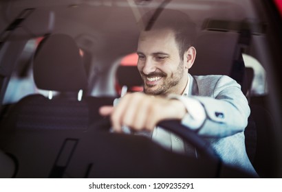 Attractive Happy Young Man Driving Car And Smiling