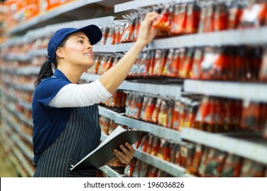 Attractive Hardware Store Worker Counting Stock