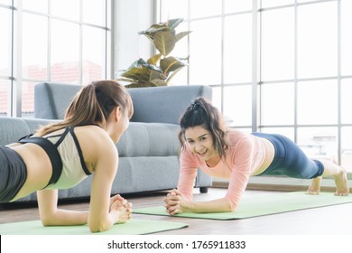 Attractive and healthy women Two Asians Exercising Stretching the muscles with yoga postures together at home. Help balance life - Powered by Shutterstock