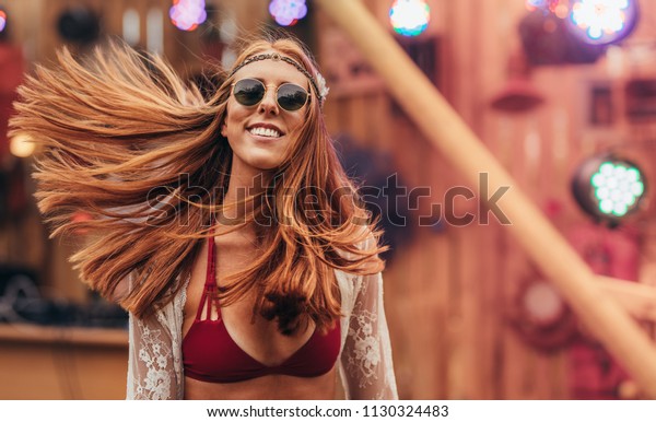 Attractive hippie woman\
at music festival outdoors. Caucasian woman in retro style outfit\
at music festival.