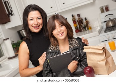 Attractive Hispanic Proud Mom With Her Pretty Schoolgirl Daughter In The Kitchen.