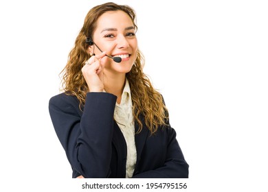 Attractive Hispanic Woman With A Headset Working As A Successful Salesperson. Professional Young Woman Holding The Microphone While Talking With A Customer And Client