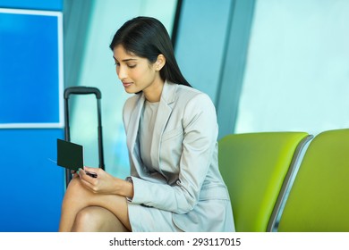 Attractive Indian Business Woman Looking At Her Air Ticket At Airport