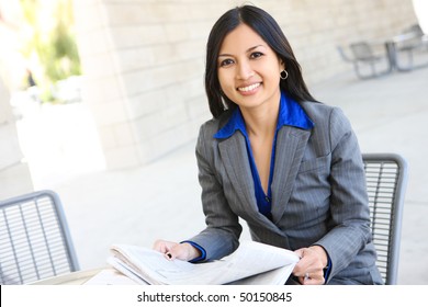An attractive Indian business woman outside office building