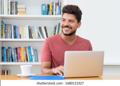 Attractive Latin American Man With Beard Working At Computer At Home