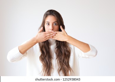 Attractive Latin Girl Closing Mouth To Keep Silent. Beautiful Elegant Young Woman Closing Lips With Hands. Isolated On White. Silence Concept