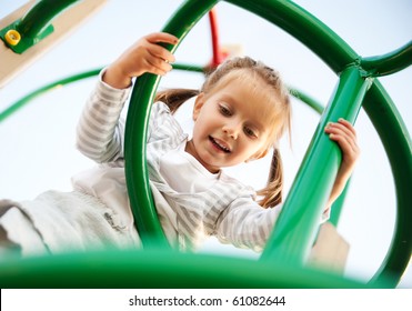 Attractive Little Girl On Outdoor Playground Equipment