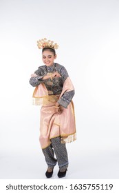 An attractive Malaysian traditional female dancer performing a cultural dance routine called Tarian Zapin in a traditional dance outfit. Full length isolated in white.