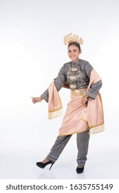 An attractive Malaysian traditional female dancer performing a cultural dance routine called Tarian Zapin in a traditional dance outfit. Full length isolated in white.