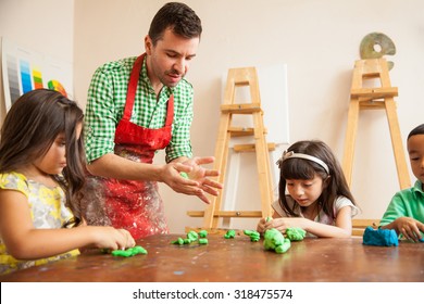 Attractive Male Art Teacher And His Students Working With Some Clay For Sculpting Class