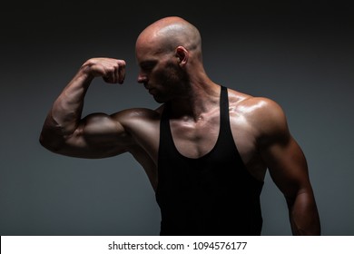 Attractive Male Body Builder Flexing His Biceps Muscles In Studio Shot. Concept Gym Life Style. 