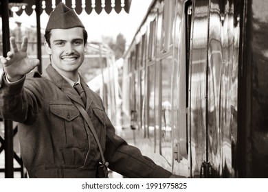 Attractive Male British Soldier In Vintage WW2 Uniform At Train Station Standing Next To Train