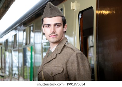 Attractive Male British Soldier In Vintage WW2 Uniform At Train Station Standing Next To Train