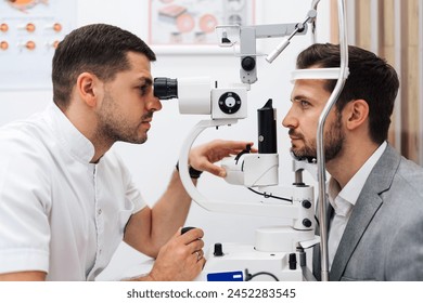 Attractive male doctor ophthalmologist is checking the eye vision of handsome middle age man in modern clinic. Doctor and patient during medical check up in ophthalmology clinic.  - Powered by Shutterstock