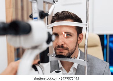 Attractive male doctor ophthalmologist is checking the eye vision of handsome middle age man in modern clinic. Doctor and patient during medical check up in ophthalmology clinic.  - Powered by Shutterstock