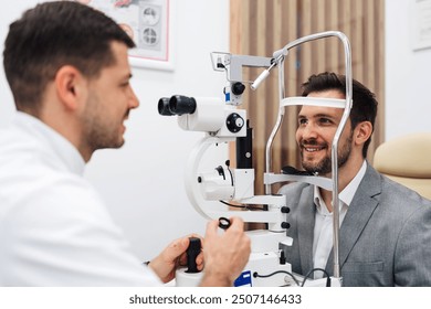 Attractive male doctor ophthalmologist is checking the eye vision of handsome middle age man in modern clinic. Doctor and patient during medical check up in ophthalmology clinic.  - Powered by Shutterstock