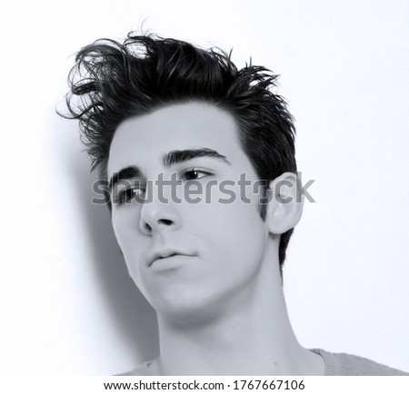 Similar – Boy with a white T-shirt in front of a dark wall