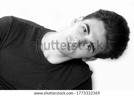 Similar – Boy with a white T-shirt in front of a dark wall